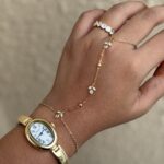 tulip hand chain jewellery for women, anti tarnish tulip hand chain in gold finish, elegant tulip hand chain with bracelet, waterproof gold hand chain for women, delicate tulip hand chain jewellery, stylish gold hand chain for festive occasions, trendy tulip hand chain accessory, modern anti tarnish hand chain, beautiful gold tulip hand chain, traditional hand chain jewellery with tulip design